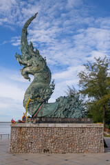 The Naga statue is spraying water to the sea in front of blue sky at Songkhla, Thailand