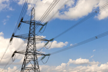 Electricity pylon with clouds and blue sky. Hertfordshire UK.  - obrazy, fototapety, plakaty