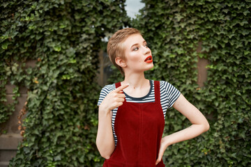 woman with short hair walking in the park a cup of coffee summer lifestyle