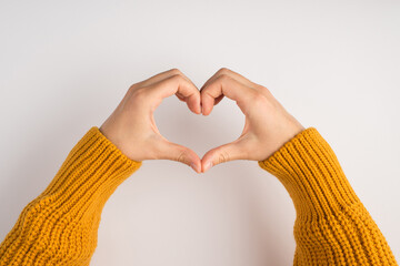 First person photo of woman's hands making heart with fingers on isolated white background with...