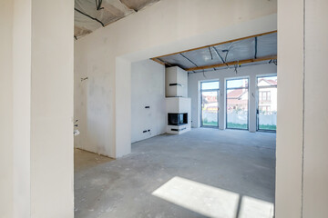 Fototapeta na wymiar Empty unfurnished room with minimal preparatory repairs. interior with white walls and fireplace