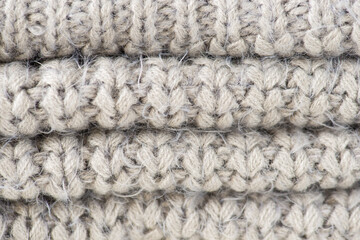 Closeup photo of folded knitted grey fabric texture
