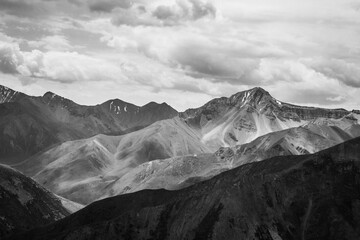 Beautiful Summer landscape: cloudy sky, hills and distant mountains. Monochrome high contrast image
