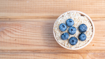Obraz na płótnie Canvas Breakfast cereals in bowl served with and blueberries. Clean eating, healthy food diet concept