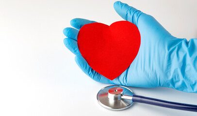 red heart in doctor's hand with medical stethoscope