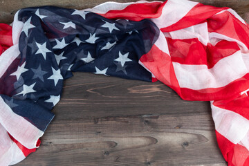 The American flag lies on a wooden background.