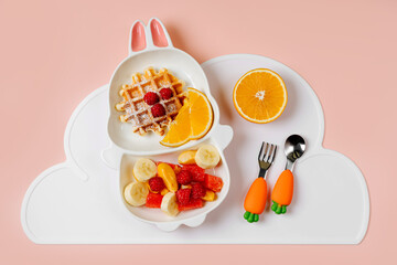 Children's Breakfast. Cute plate in the shape of a bunny with waffles and fruits. Food idea for kids.