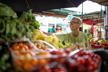 Elderly woman buying fresh organic vegetables at market place for healthy nourishment.