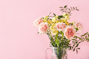 Bouquet of pink carnations and yellow matthiola with green branches. Design concept of holiday greeting with carnation bouquet on pink background