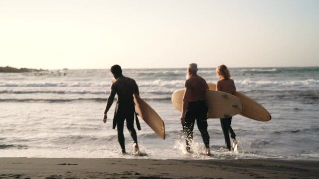 Happy surfers fun surfing during sunset time - Extreme sport lifestyle and friendship concept