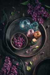 Glass with flower lilac oil. Lilac flower products.