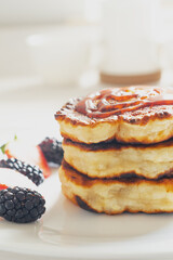 pancakes on a light background with jam and berries