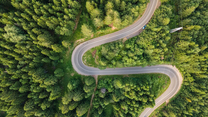 Winding road from the high mountain pass in Kopaonik, Serbia. Great road trip trough the dense woods. Aerial view.