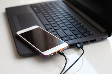 close-up usb cable connect phone and laptop computer new technology concept