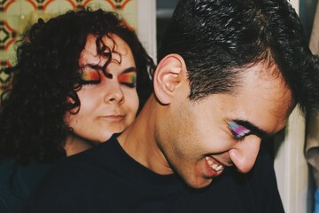 Portrait of queer friends / young couple wearing eyeshadow makeup of lgbtq rainbow pride flag & trans pride flag *2