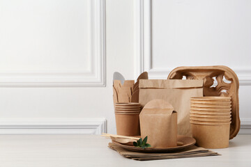 Disposable eco friendly products on white wooden table. Space for text