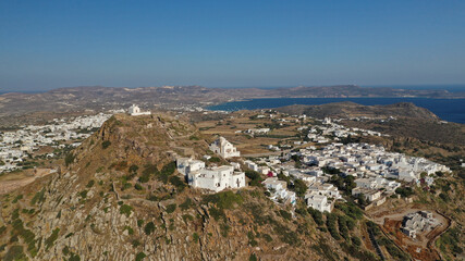 Fototapeta na wymiar Aerial drone photo from uphill Venetian castle and small chapel overlooking the Aegean sea on top of scenic cliff in chora, capital of Milos island, Cyclades, Greece