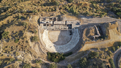 Aerial drone photo of iconic ancient theatre of Milos overlooking the Aegean sea where statue of...