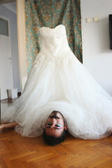Portrait of young mans face with makeup under a bridal wedding gown