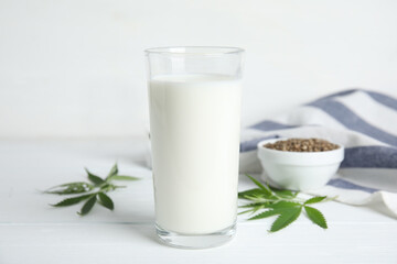 Obraz na płótnie Canvas Glass of fresh hemp milk on white wooden table