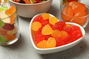 Delicious gummy candies on light grey table, closeup