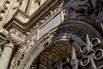 Obraz premium Details of the Door of Forgiveness of the Cathedral of Granada with allegories of Faith and Justice with a card