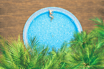 Young alone, beautiful sports woman in bikini and hat is swimming in swimming pool, hydro massage...