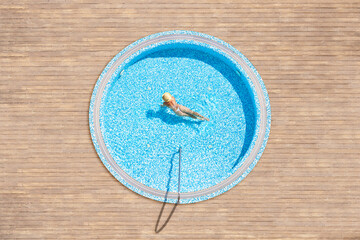 Young alone beautiful sports woman in bikini and hat is swimming in hydro massage bath on wooden...