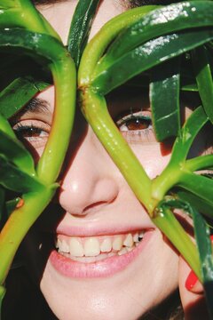 Closeup portrait of young woman's face smiling with green seaweed leaves 