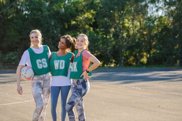 horizontal shot of three young women in sports wear posing for the camera on a sunny day