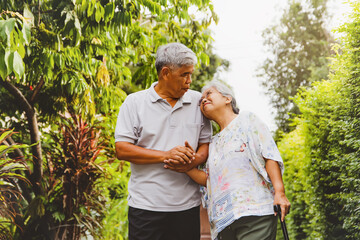 Senior couple, a strong relationship, lasting forever : Elderly couple walking in the shady front garden, dressed comfortably. Walking hand in hand and happy together
