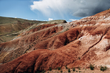 Red mountains against the backdrop of a dramatic sky