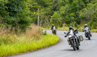 Men riding their adventure motorbikes on windy road in Cambodia
