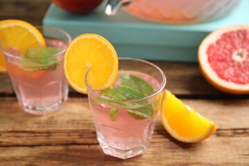 Delicious refreshing drink with orange and mint on wooden table