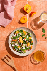 Summer peach and cheese salad on tile table, top view