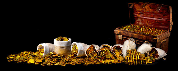 Stacking lots of gold coins in treasure chest old on black background