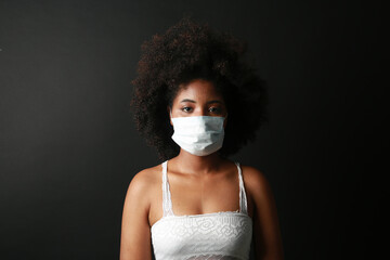 portrait of african woman in medical mask on black background 