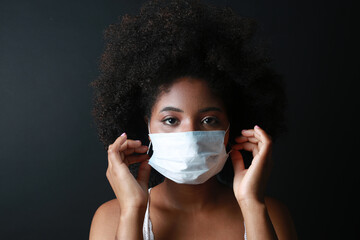 portrait of african woman in medical mask on black background 