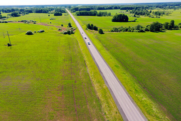 Highway through fields and arable land. View from above. Summer rural landscape