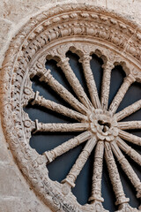 Round window on an old church with carved ornaments
