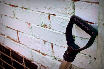plastic shovel handle against the wall