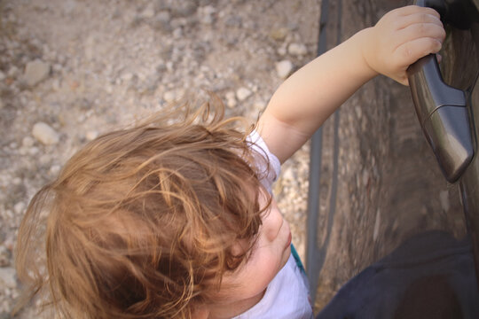 Ni&ntilde;o peque&ntilde;o queriendo abrir la puerta de un coche.