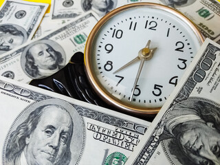 Watch and assorted American banknotes. Time is money idea
