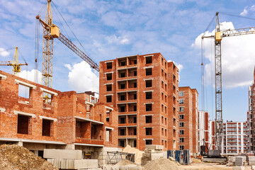 Multi-storey buildings under construction. Construction site with a tower crane and concrete blocks