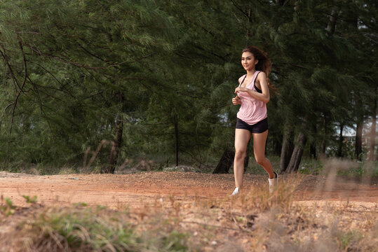 Young beautiful woman in sportswear doing exercise running on beach in the morning,  for good health and strong.