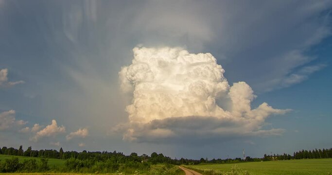 Isolated thunderstorm, white cumulonimbus clouds tower rising in the evening sky