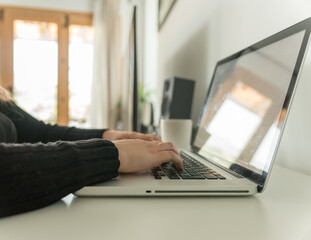 woman's hands typing on laptop