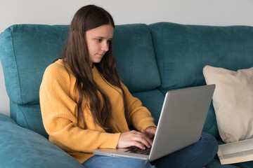 girl studying with laptop on sofa