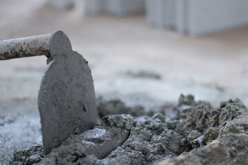 Cement mixed in a mortar mixing bucket for building construction using a hoe as a tool for mixing. Cement mixing concept, manual, labor occupation.