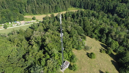 Pappenheim, Germany Bavaria - August 1, 2021: Wide Area Network (WAN) 3G 4G 5G LTE mobile radio broadband transceiver communications tower with, trees, srubs , and view from above.